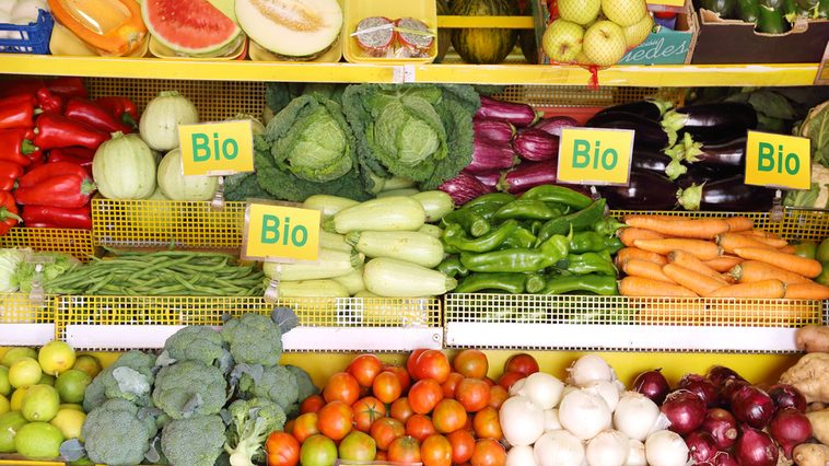Das Bild zeigt ein Bio-Obst- und -Gemüseregal in einem Supermarkt.